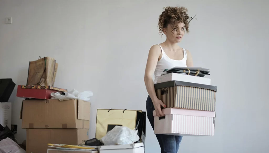woman walking with boxes in hand and in the background
