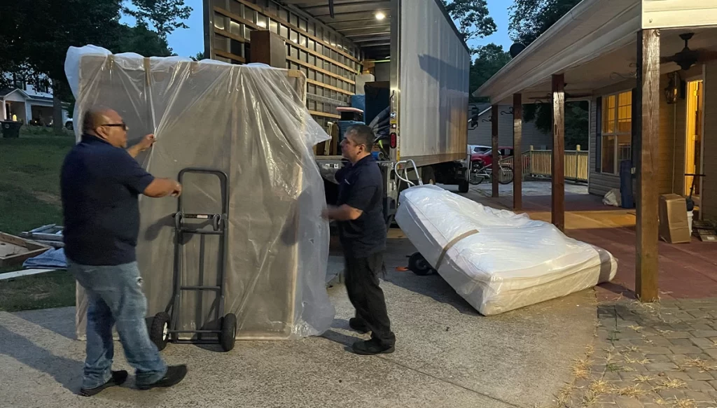 movers placing a bedframe on a dolly