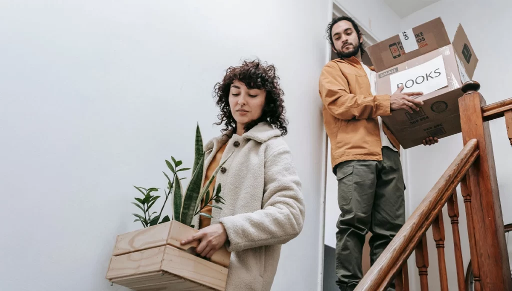 tennants walking down stairs with boxes