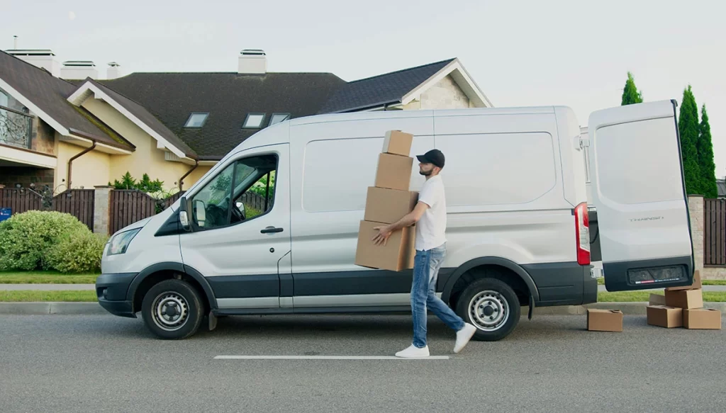 man carrying boxes out of a vehicle