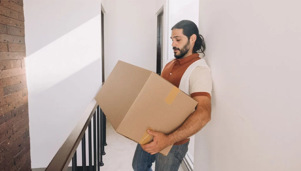man carrying a large box down a hallway