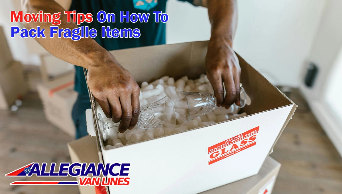 professional mover adds glass cups to a padded box